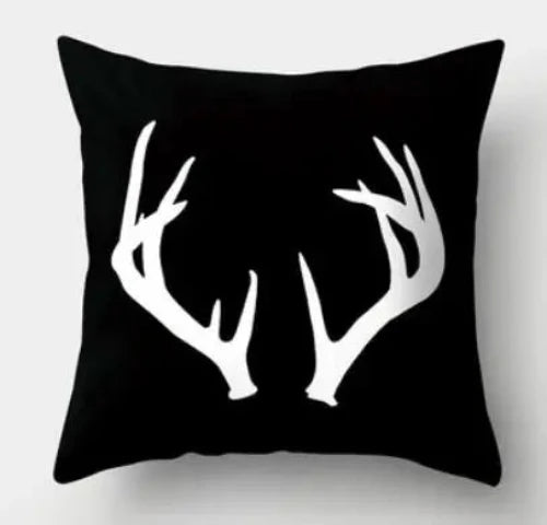 A black square throw pillow with white deer antlers.