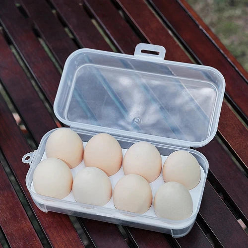 This picture is taken on a wooden table at a campsite. The egg storage container is open and shows the grids for easy travel