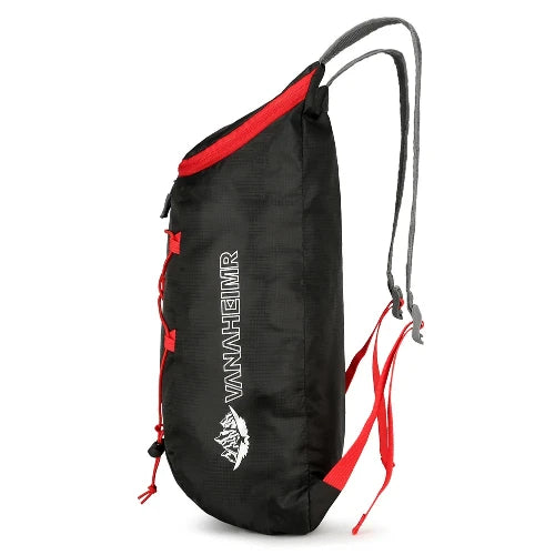 On white background. this backpack is shown sideways. Black backpack with red straps. 