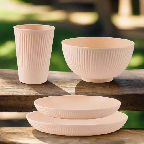 A pink wheat straw dinnerware set. The set includes one large plate, one small plate, one bowl and one cup.