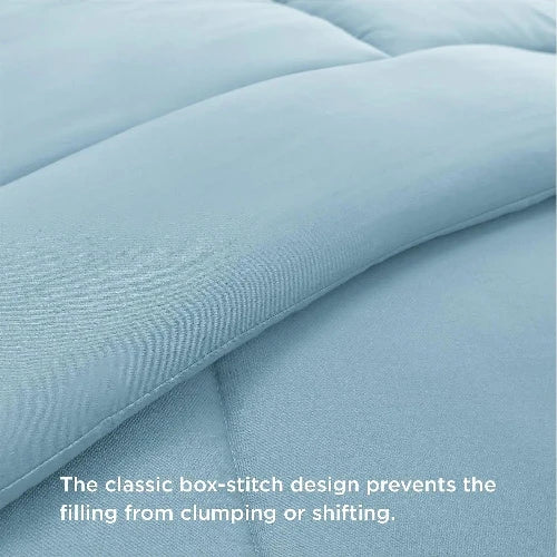 A close up of a light and fluffy baby blue duvet insert/comforter with the top folded down and text that says, "The classic box-stitch design prevents the filling from clumping or shifting."