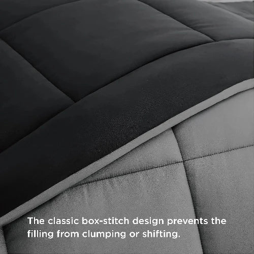 A black and grey reversable duvet insert for your comfort with the top folded down and text that says, "The classic box-stitch design prevents the filling from clumping or shifting."