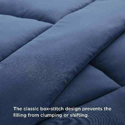 A cozy blue duvet insert with the top folded down and text that says, "The classic box-stitch design prevents the filling from clumping or shifting."