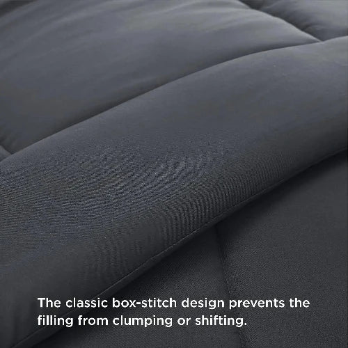 A close up of a cozy dark grey duvet insert/comforter with the top folded down and text that says, "The classic box-stitch design prevents the filling from clumping or shifting."