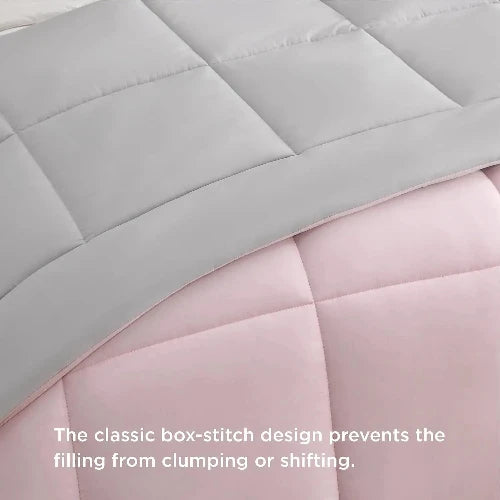 A fluffy grey and light pink reversable duvet insert/comforter with the top folded down and text that says, "The classic box-stitch design prevents the filling from clumping or shifting."