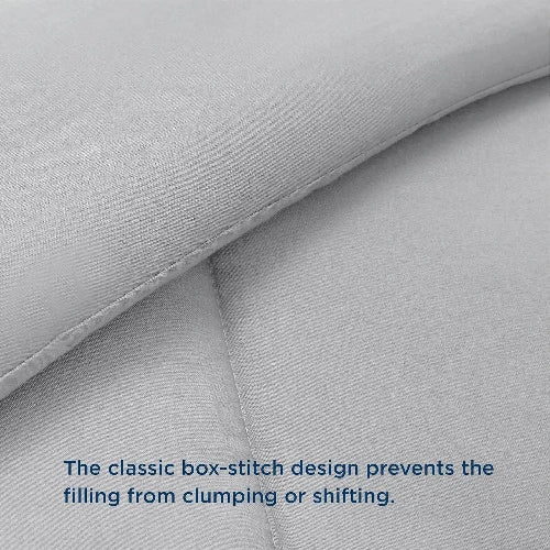 A close up of a light grey duvet insert four your comfort with the top folded down and text that says, "The classic box-stitch design prevents the filling from clumping or shifting."