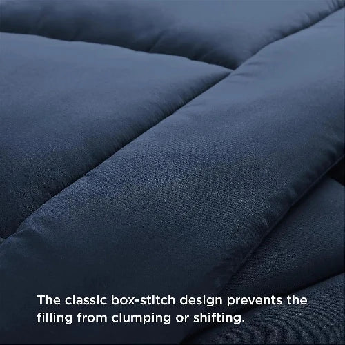 A close up of a fluffy navy-blue duvet insert/comforter with the top folded down and text that says, "The classic box-stitch design prevents the filling from clumping or shifting."