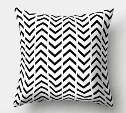 A white square throw pillow with eight rows of a repeating black arrows pattern. Every other row points up or down.