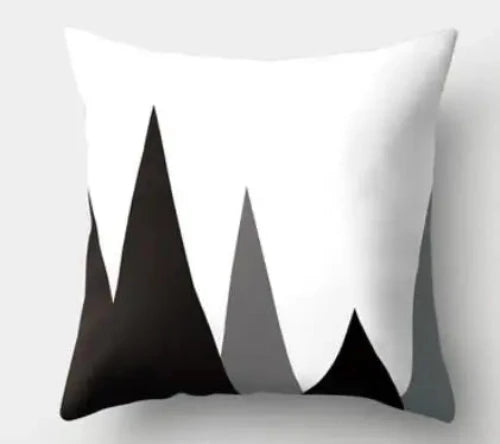 A white throw pillow with three black triangles and one grey triangle of various heights depicting mountains.