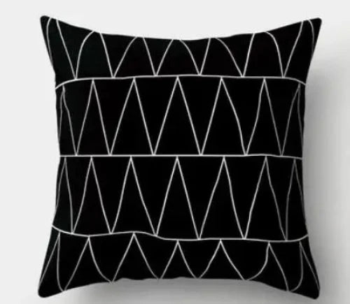 A black square throw pillow with four rows of a repeating pattern of white triangles.