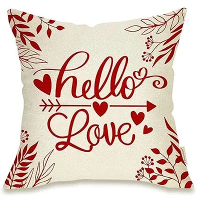 Picture of White Pillow Cover that has Red Leaves and Flowers in Corners, Cursive Lettering says "Hello Love" with an arrow through the middle, several hearts placed throughout the cover. 