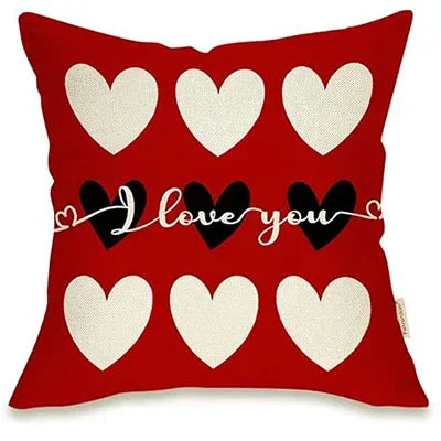 Red Pillow with Three red hearts at top and bottom of cover, three black hearts in middle saying "I love you" In white cursive over black hearts