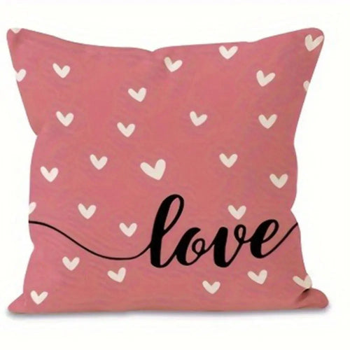 Pink pillow cover with many small white hearts throughout.  Love in decorative font on bottom right hand corner. 