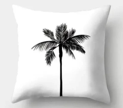 A white square throw pillow with a black palm tree design on it.