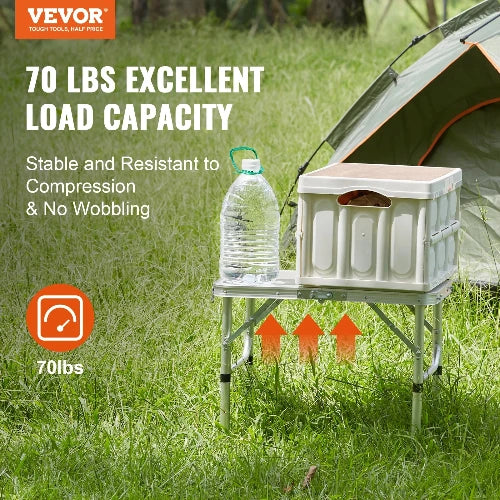 This picture features the wild style aluminum table by VEVOR on a grassy field, in front of a tent.  The table can hold up to 70 lbs. is stable and resistant to compression. No wobbling.  The picture shows how the table can expand tall, or go short for a nice sided table.