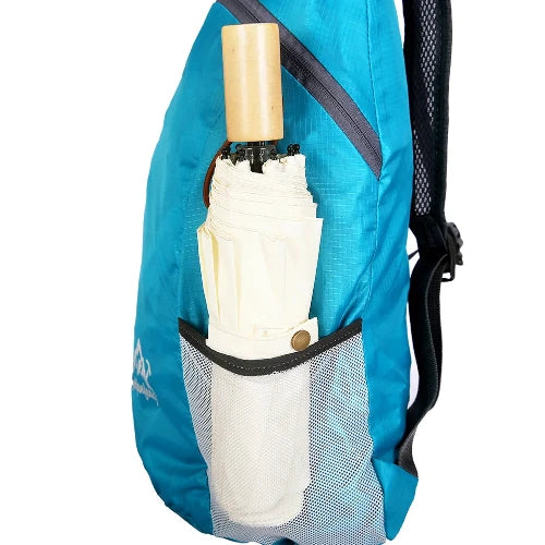 on white background, this side view of the backpack shows how it can easily fit a compactable umbrella in the mesh pocket. it shows the backpack straps and angled sipper compartment.